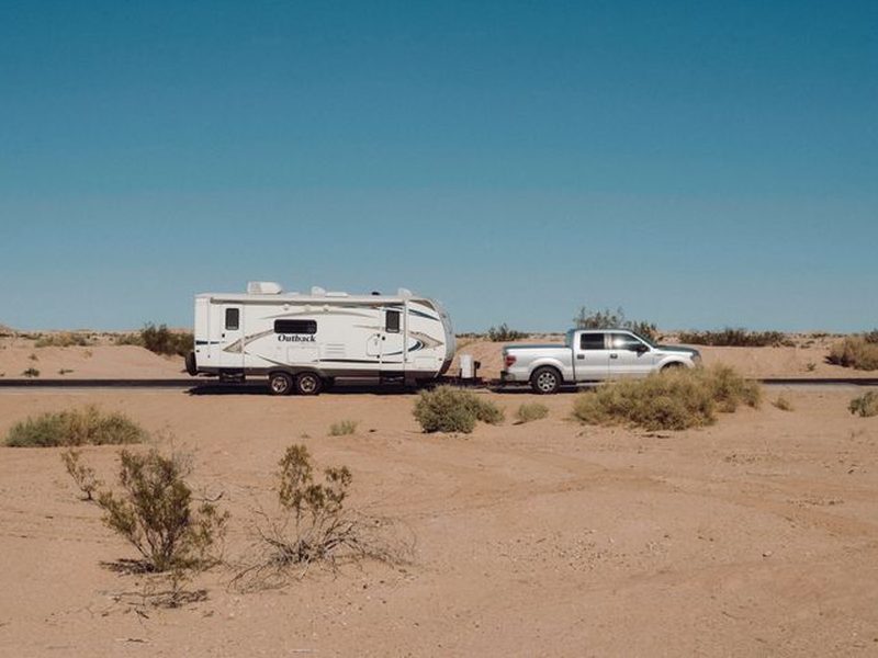 Modern pickup truck towing a trailer on the road