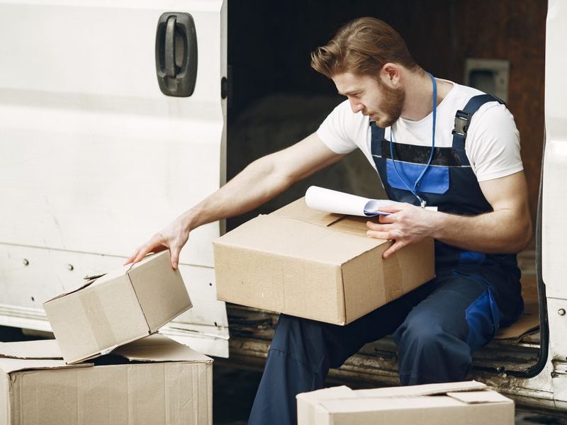 Uniformed worker organizing boxes for pickup